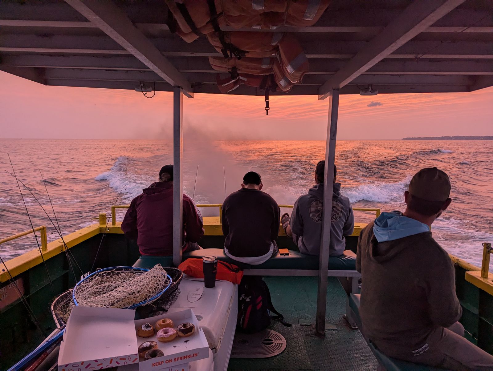 Harral and Stevenson team members on a charter boat at sunrise on Lake Erie